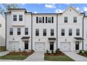 Attractive three-story townhomes, with attached garages, pristine white exteriors, and charming curb appeal at 3142 Washburn St, Atlanta, GA 30354
