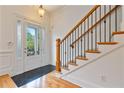 Bright foyer featuring a wood staircase, black tile, a glass-paneled door and light hardwood floors at 1003 Pearl Ne Pt, Sandy Springs, GA 30328