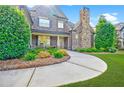 Charming home with brick facade, stone chimney, and lush landscaping at 468 Scott Farm Dr, Powder Springs, GA 30127