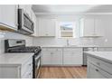 Modern kitchen with stainless steel appliances, stone countertops and hardwood floors at 470 Village Ln, Fairburn, GA 30213