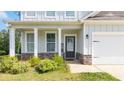 Charming home entrance with white pillars, stone accents, and a welcoming front door at 20 Tarpley Way, Covington, GA 30016