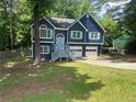 Charming two-story home featuring a blue exterior, complemented by a spacious front yard and a convenient two-car garage at 4790 Brandon Acres Ln, Buford, GA 30519