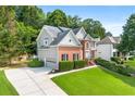 Beautiful two-story home with brick and gray siding, a lush green lawn, and mature trees offering shade and privacy at 1265 Timberline Pl, Alpharetta, GA 30005