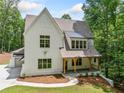 Beautiful white home features an attached two-car garage and welcoming front porch at 2585 Hickory Rd, Canton, GA 30115