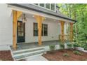 Charming front porch with stone flooring, wooden support beams, and elegant light fixture at 2585 Hickory Rd, Canton, GA 30115