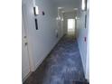 Hallway with gray patterned carpet, white walls, and lighting sconces at 3655 Peachtree Rd # 203, Atlanta, GA 30319