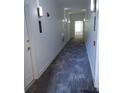 Long hallway with bright lighting, neutral paint and patterned carpet leading to the condominium entrance at 3655 Peachtree Rd # 203, Atlanta, GA 30319