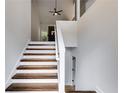 Bright staircase with hardwood steps, white risers, and a contemporary open railing design at 130 Opal Ln, Carrollton, GA 30116