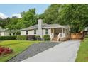 Charming exterior featuring a chimney, well-maintained lawn, and inviting front porch at 1605 Wellswood Se Dr, Atlanta, GA 30315