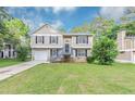 Charming home with a well-manicured lawn, gray siding, and a covered porch entry at 5290 Forest Downs Ln, Atlanta, GA 30349