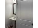 Tastefully designed powder room with a pedestal sink, framed mirror and white door at 707 Dodd N Ln # 164, Buford, GA 30518