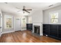 Living room featuring hardwood floors, a cozy fireplace, built in bookcases and natural light from the windows at 763 Jones Nw Ave, Atlanta, GA 30314