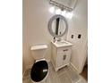 Stylish half bathroom with white vanity, decorative mirror, and gray tile flooring at 3793 Mays Sw Ct, Atlanta, GA 30331