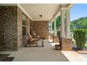Inviting covered porch with rocking chairs and brick pillars, perfect for relaxing at 813 Cotton Creek Dr, Canton, GA 30115
