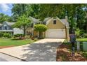 Inviting home features a large driveway, mature landscaping, and an attached two-car garage at 9050 Brockham Way, Alpharetta, GA 30022