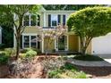 Attractive home featuring mature landscaping, manicured flower beds, and a welcoming entrance at 9050 Brockham Way, Alpharetta, GA 30022