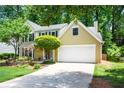 Traditional two-story home with a well-maintained lawn, landscaping, and attached garage at 9050 Brockham Way, Alpharetta, GA 30022
