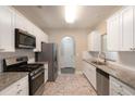 Modern kitchen features granite countertops, stainless steel appliances, white cabinets, and tiled backsplash at 5712 Grande River Rd, Atlanta, GA 30349