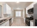 Modern kitchen features granite countertops, stainless steel appliances, white cabinets, and tiled backsplash at 5712 Grande River Rd, Atlanta, GA 30349
