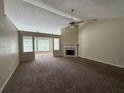 Spacious living room with plush carpeting, a fireplace, and expansive windows for natural light at 124 Sparkling Spring Trl, Mcdonough, GA 30252