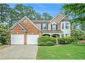 Charming two-story home featuring a manicured lawn, brick accents, and a convenient two-car garage at 2717 High Creek Run, Dacula, GA 30019