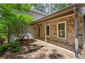 Inviting stone-accented entrance featuring a tiled patio, providing a charming and sheltered entryway to the home at 3665 Pine St, Atlanta, GA 30340