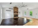 Spacious living room with a unique stone fireplace, hardwood floors, and large windows showcasing the outdoor view at 3665 Pine St, Atlanta, GA 30340