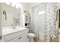 Well-lit bathroom with white cabinets, shower, and decorative shower curtain at 5744 Cypress Bluff Ln, Hoschton, GA 30548