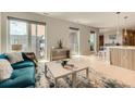 Open-concept living area with modern decor, light hardwood floors, blue sofa, and views of the city at 775 Juniper Ne St # 612, Atlanta, GA 30308