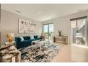 Bright living room featuring stylish decor, a comfortable blue sofa, and large windows at 775 Juniper Ne St # 612, Atlanta, GA 30308