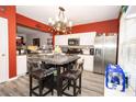Stylish kitchen featuring stainless steel appliances, hardwood flooring and a decorative chandelier at 9155 Nesbit Ferry Rd, Alpharetta, GA 30022
