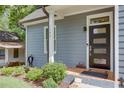 Inviting front porch with a modern door, manicured bushes and clear house number create a welcoming entrance at 1143 Church Nw St, Atlanta, GA 30318