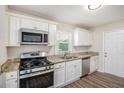 Modern kitchen featuring stainless steel appliances, white cabinets, and granite countertops at 3204 Robin Rd, Decatur, GA 30032