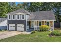 Charming two-story home featuring a stone facade, gray siding, shutters, a well-manicured lawn, and a two-car garage at 4865 Fenbrook Dr, Stone Mountain, GA 30088
