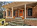 Inviting front porch with brick steps, columns, and a brightly colored front door at 100 Hall Pl, Fayetteville, GA 30215