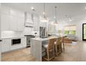Bright, open kitchen featuring an island with bar seating, stainless steel appliances, and hardwood flooring at 8240 Sonata Ln, Cumming, GA 30041
