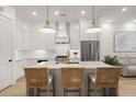 Bright kitchen features a marble island with seating, pendant lights and modern, stainless steel appliances at 8240 Sonata Ln, Cumming, GA 30041