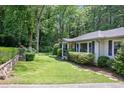 Charming home with a neatly manicured lawn, accented by stone retaining wall and mature trees at 184 Rambo Sw Pl, Marietta, GA 30064
