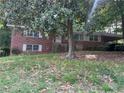 Traditional brick home with mature trees and a carport, offering a blend of classic charm and convenient parking at 185 W Lake Nw Dr, Atlanta, GA 30314