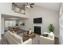 Open-concept living area with fireplace flowing into dining room with a view of the loft at 2447 Stancrest Ln, Lawrenceville, GA 30044