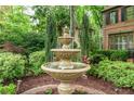 A tiered fountain surrounded by lush landscaping adds elegance to the home's exterior at 230 Leaf Court, Alpharetta, GA 30005