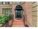 A brick walkway leads to the front door, framed by an awning, sidelights and manicured landscaping at 230 Leaf Court, Alpharetta, GA 30005