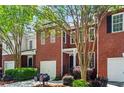 Charming brick townhome with mature landscaping, attached garages, and tree-lined street at 4910 Longcourt Se Trce # 13, Atlanta, GA 30339