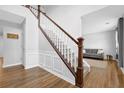 Bright foyer featuring hardwood floors, staircase with white railings, and neutral paint at 516 Broad Head Pt, Suwanee, GA 30024