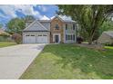 Beautifully landscaped two-story house with a two car garage, stone accents, and green lawn at 516 Broad Head Pt, Suwanee, GA 30024