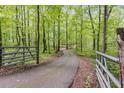 Private driveway winding through a lush, green forest, gated for added security and seclusion at 7720 Milam Rd, Winston, GA 30187