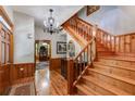 Elegant foyer with hardwood floors, a staircase, a chandelier, and decorative woodwork, showcasing classic elegance at 7720 Milam Rd, Winston, GA 30187