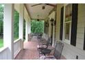 Inviting front porch with mosaic-tiled floor and wrought-iron seating perfect for enjoying the outdoors at 7720 Milam Rd, Winston, GA 30187