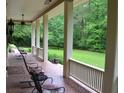 Relaxing covered front porch overlooking lush green lawn at 7720 Milam Rd, Winston, GA 30187