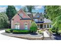 Charming two-story brick home with a fountain, manicured landscaping, and elegant curb appeal at 8525 Saint Marlo Fairway Drive, Duluth, GA 30097